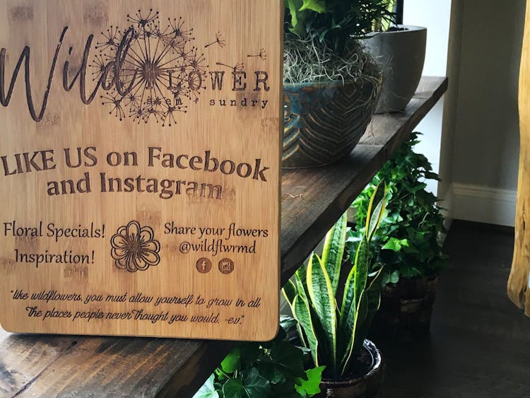 Posed with the potted plants, a wooden sign encourages visitors like us on Facebook and Instagram