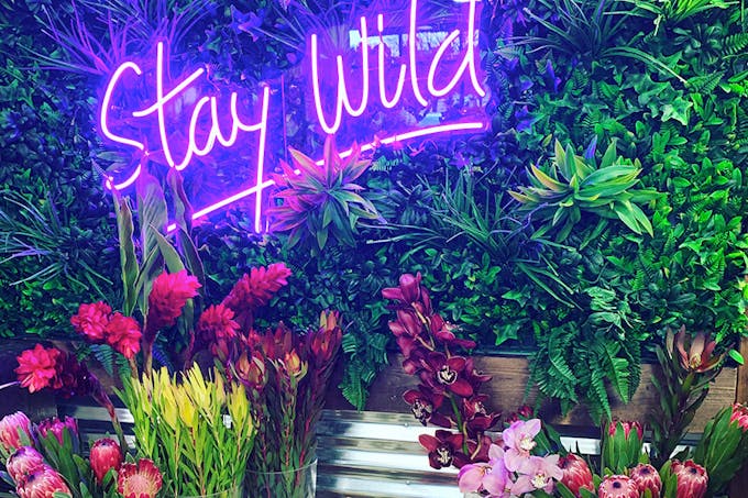 Stay Wild, encourages a neon sign inside our floral design studio