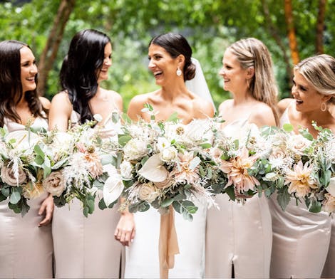 A full wedding party, bride and four bridesmaids, in a casual posed photo